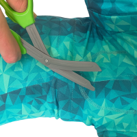 Cutting a male opening in a dog recovery suit following marked guidelines